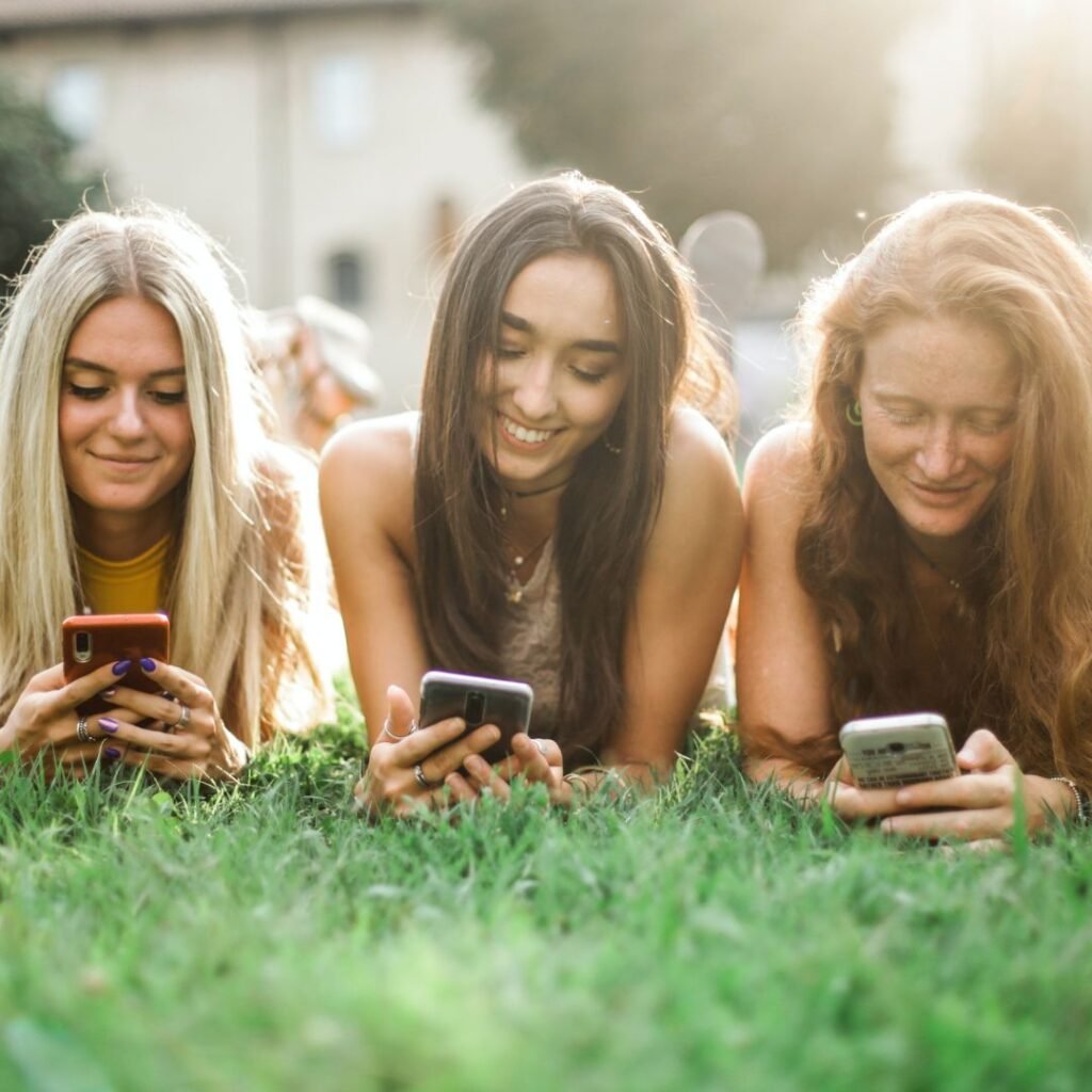 Three girls looking at social media for a Fort Collins fashion boutique